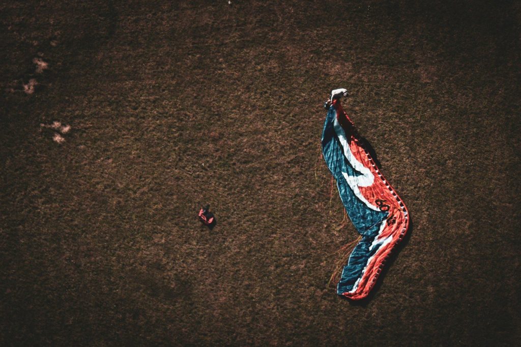 Paraglider wing lying on grassy field