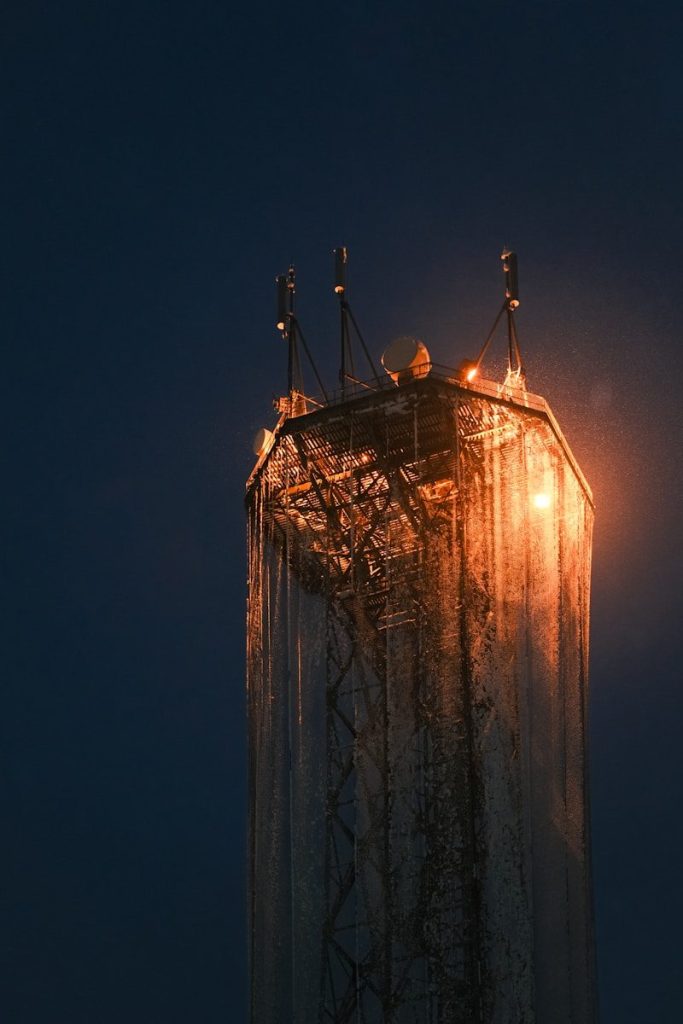 Tall tower structure illuminated by warm light at dusk