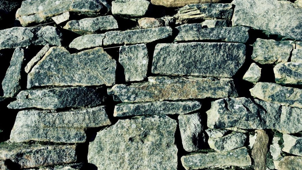 A textured wall made of rough grey stones.