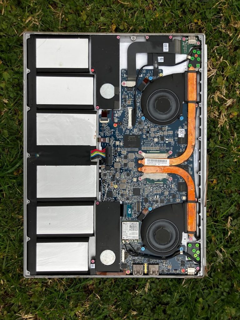 A laptop computer sitting on top of a grass covered field