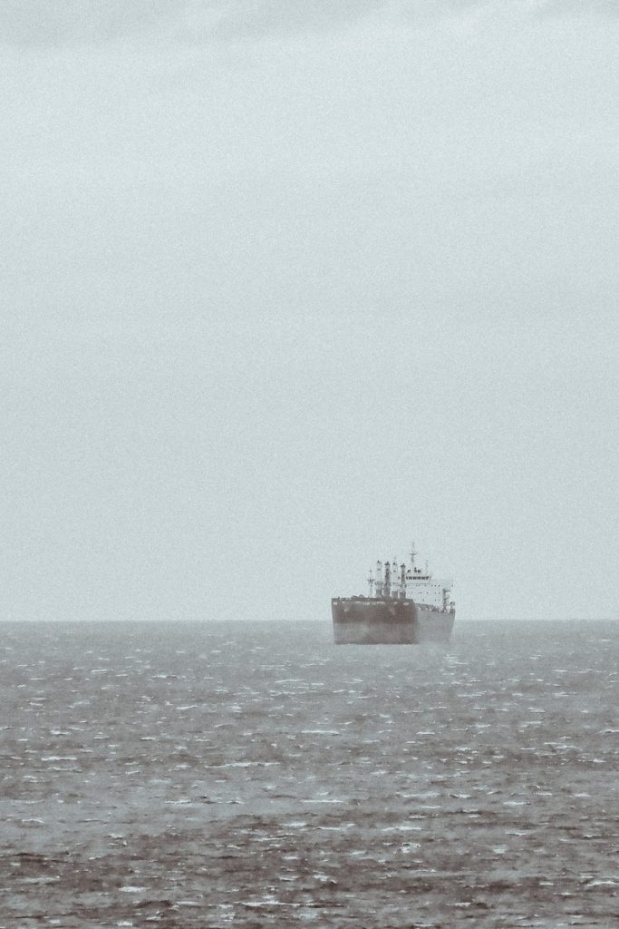 A large cargo ship sails on a choppy sea.