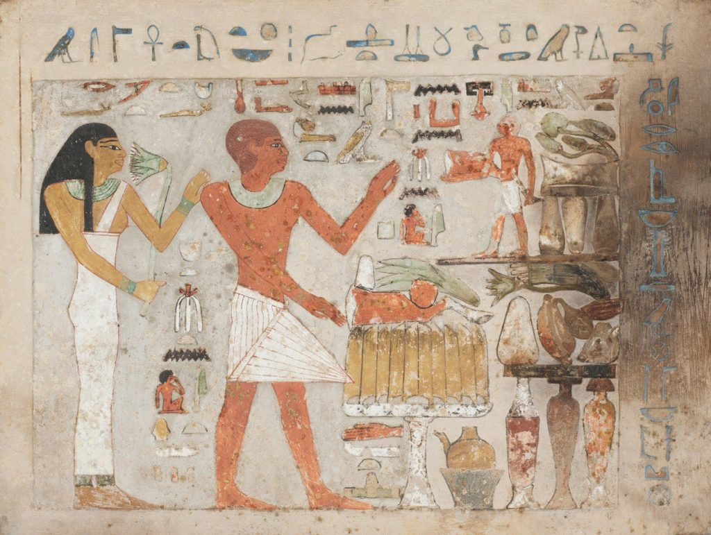 Ancient egyptian hieroglyphs and figures on a tomb wall.