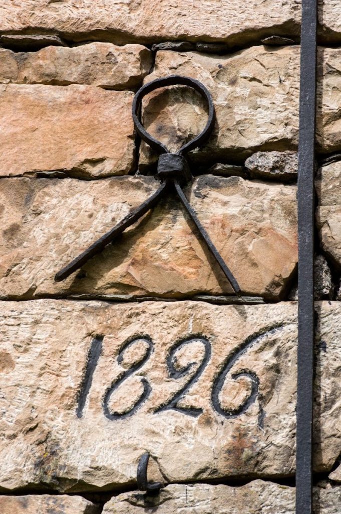 a stone wall with a pair of scissors on it