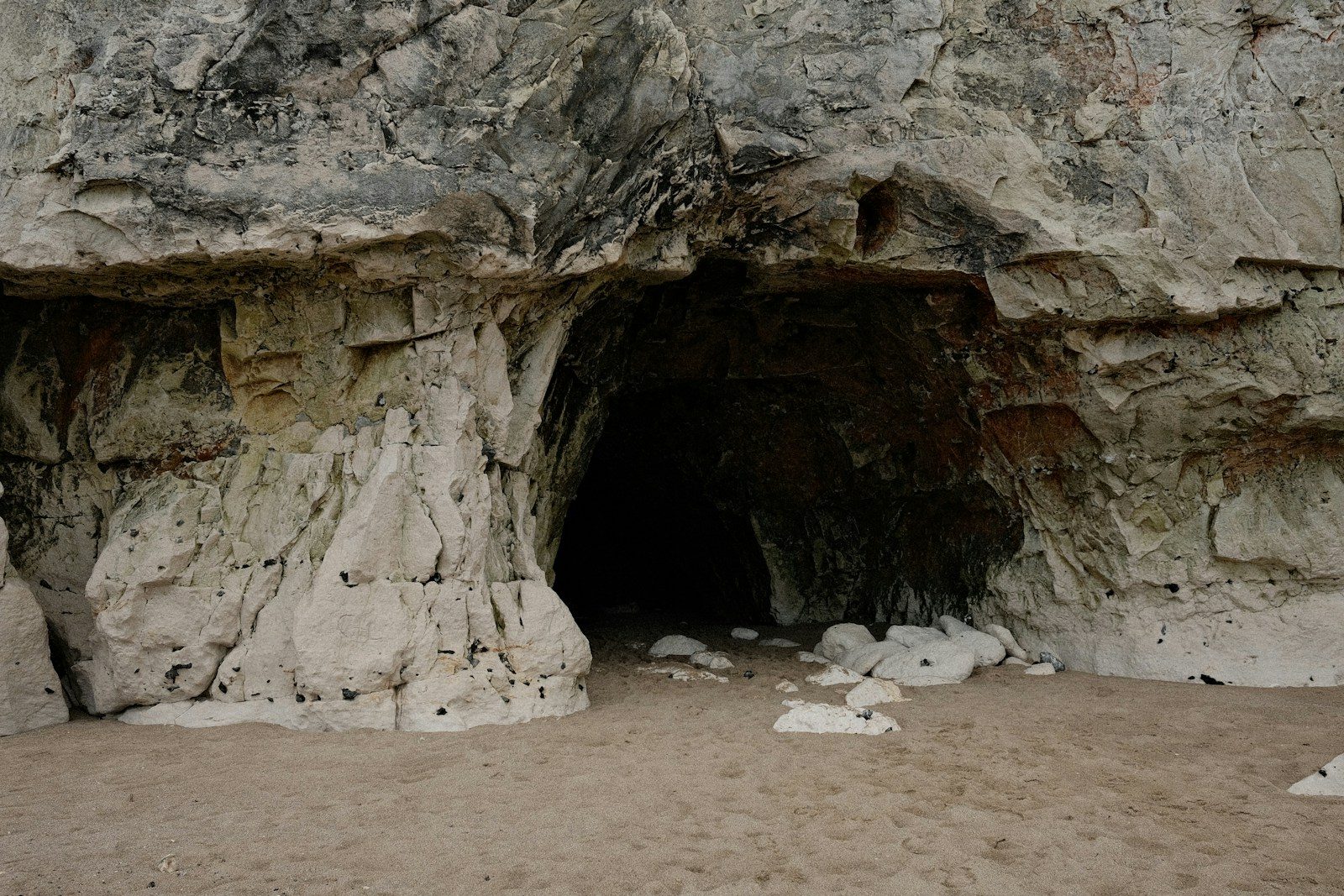 Entrance to a dark cave in a rocky cliff