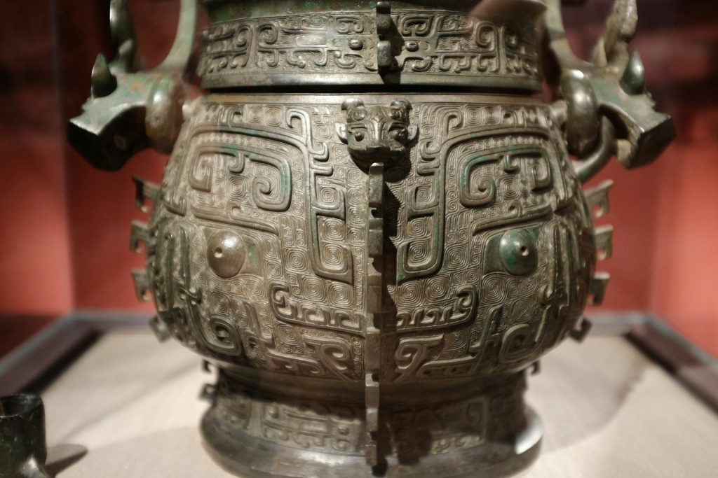 a large metal vase sitting on top of a table