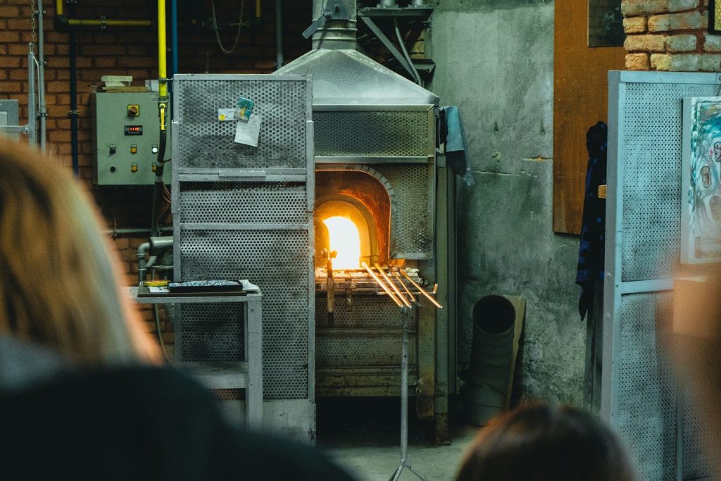a woman standing in front of a wood burning oven