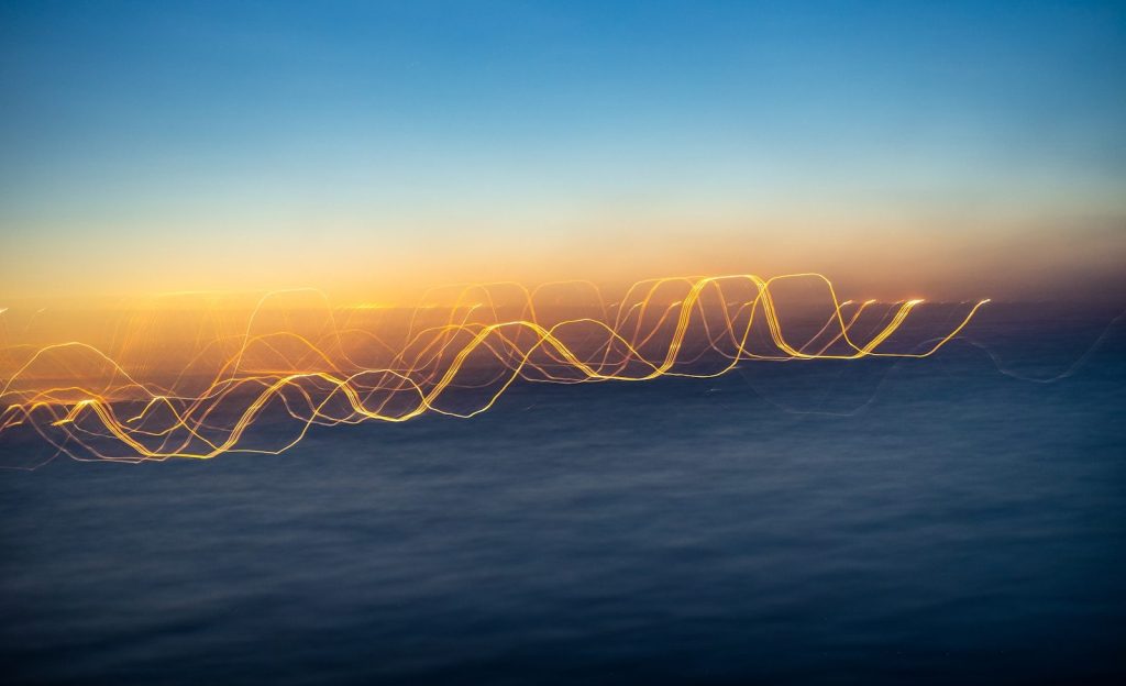 Abstract light trails against a blue and orange backdrop.