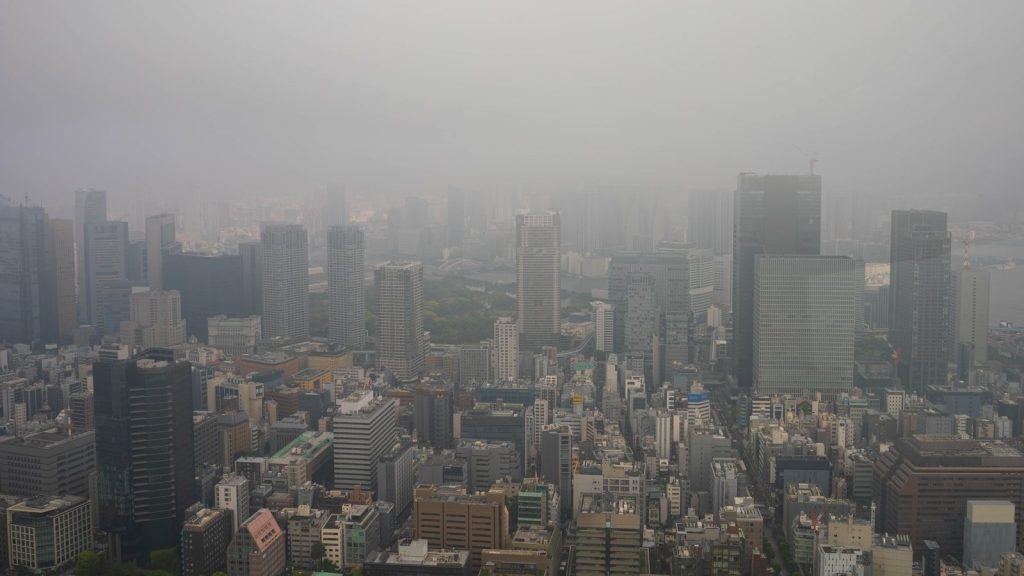 Dense urban cityscape enveloped in a thick haze.