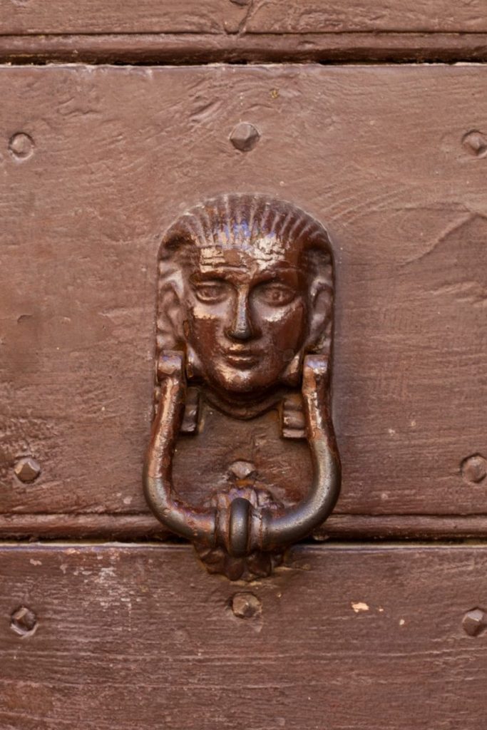 A close up of a door handle on a wooden door