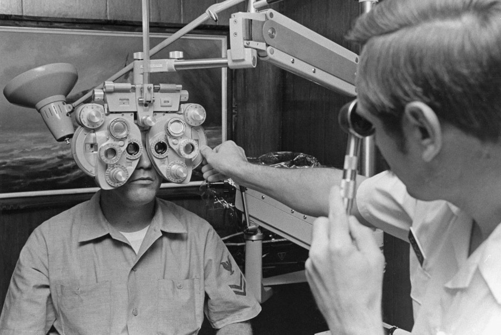 Eye exam with phoropter machine and doctor