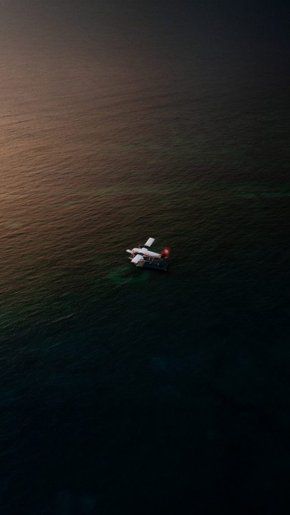 A small plane flying over the ocean at night