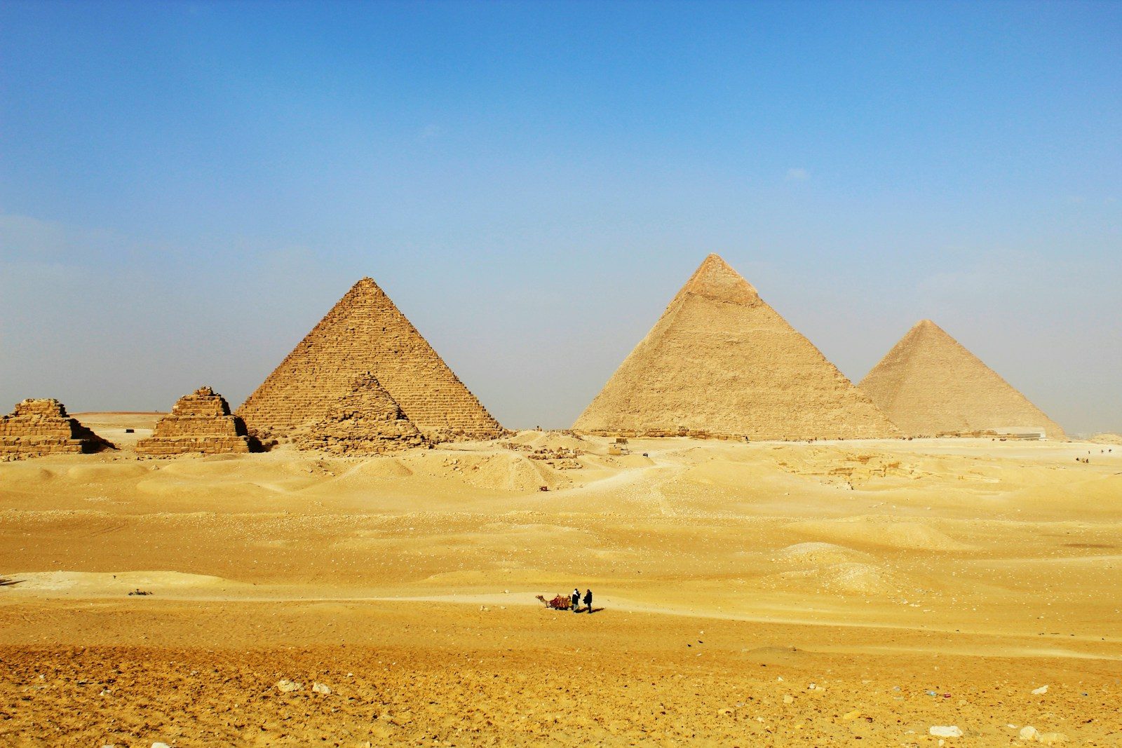a group of pyramids in the desert with a sky background