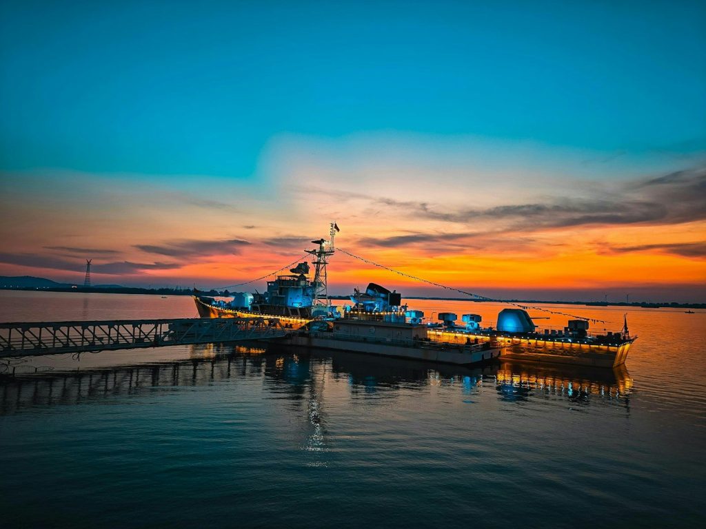 Two ships docked at sunset with colorful sky