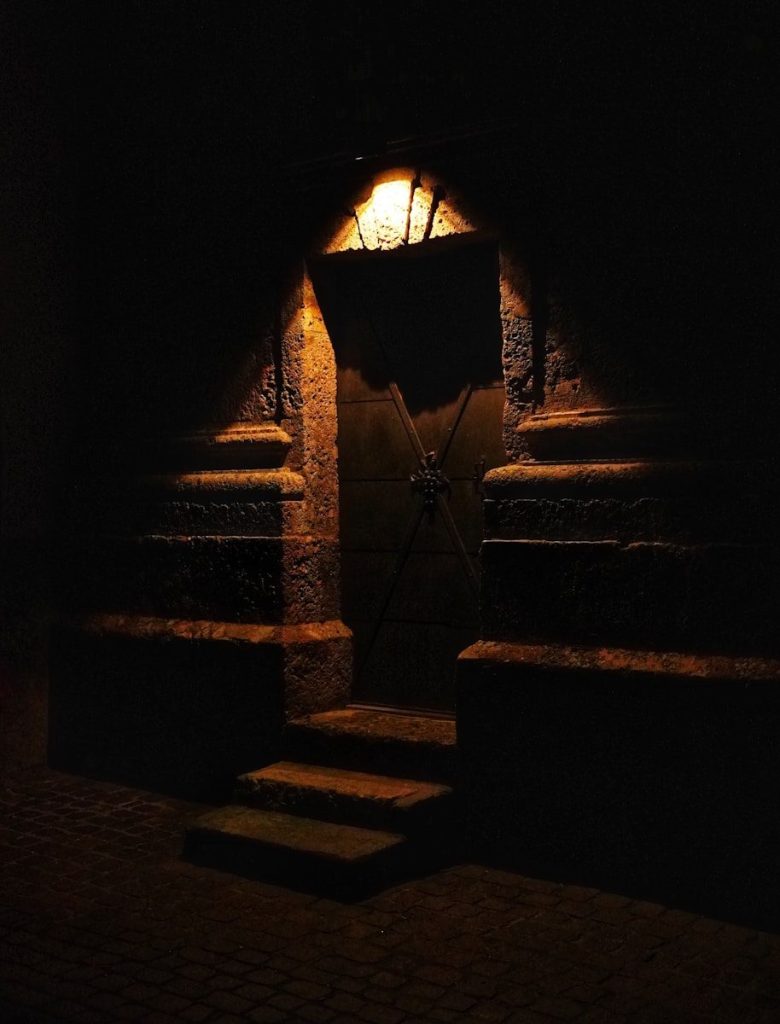 a dark room with steps leading to a door