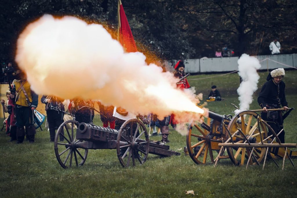 Outdoor historical reenactment in Bratislava featuring cannon fire and costumed participants.