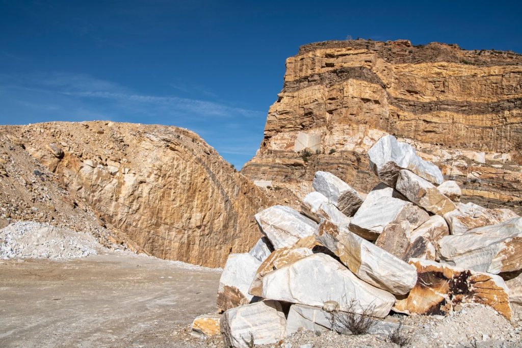Explore stunning rock formations in a barren quarry under a clear blue sky.