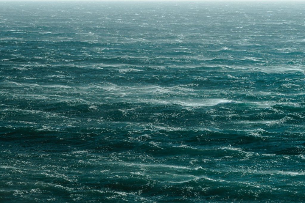 a large body of water with a boat in the distance