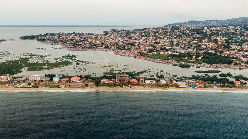 A stunning aerial view of a coastal city with a prominent harbor and lush greenery.