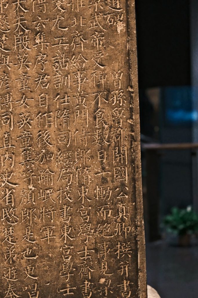 Close-up of an ancient stone tablet with traditional Chinese inscriptions, showcasing cultural heritage.
