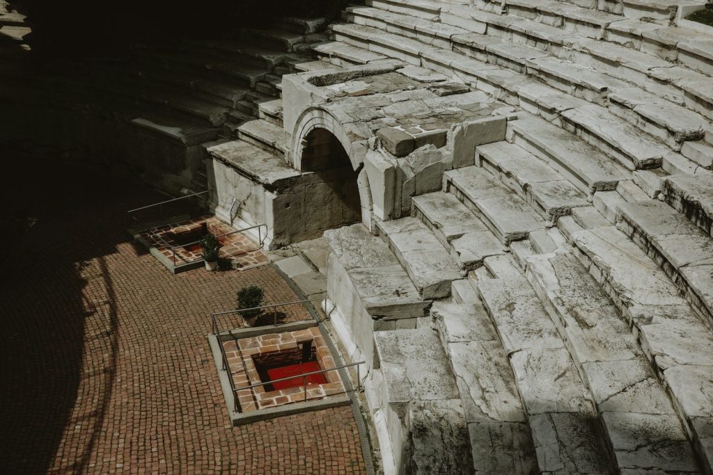 Ancient stone amphitheater seating with arched entrance