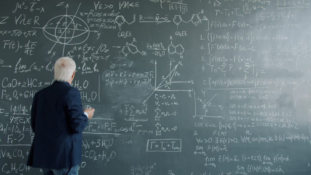 Professor writing complex formulas on a chalkboard