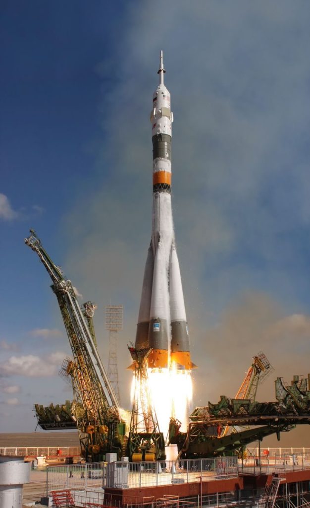 A powerful rocket launch lifting off with smoke and fire, ascending into a clear sky.