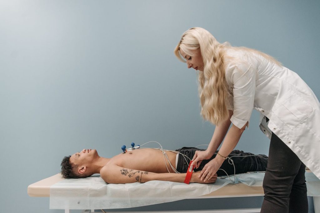 A healthcare professional performs an ECG on a patient in a clinical setting.