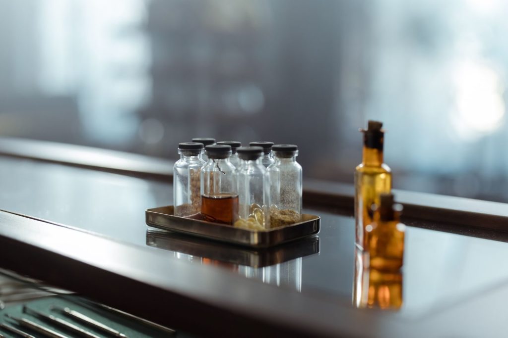 A captivating arrangement of medicine bottles on a reflective surface, evoking a sense of chemistry and alchemy.