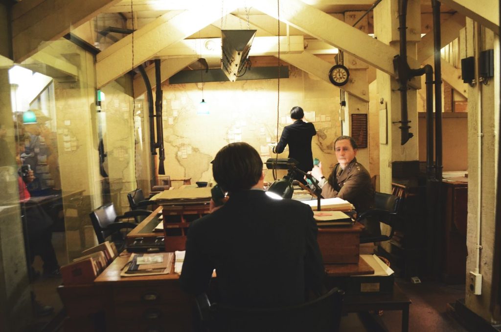Vintage scene of officers working in a historic war room with maps and desks.