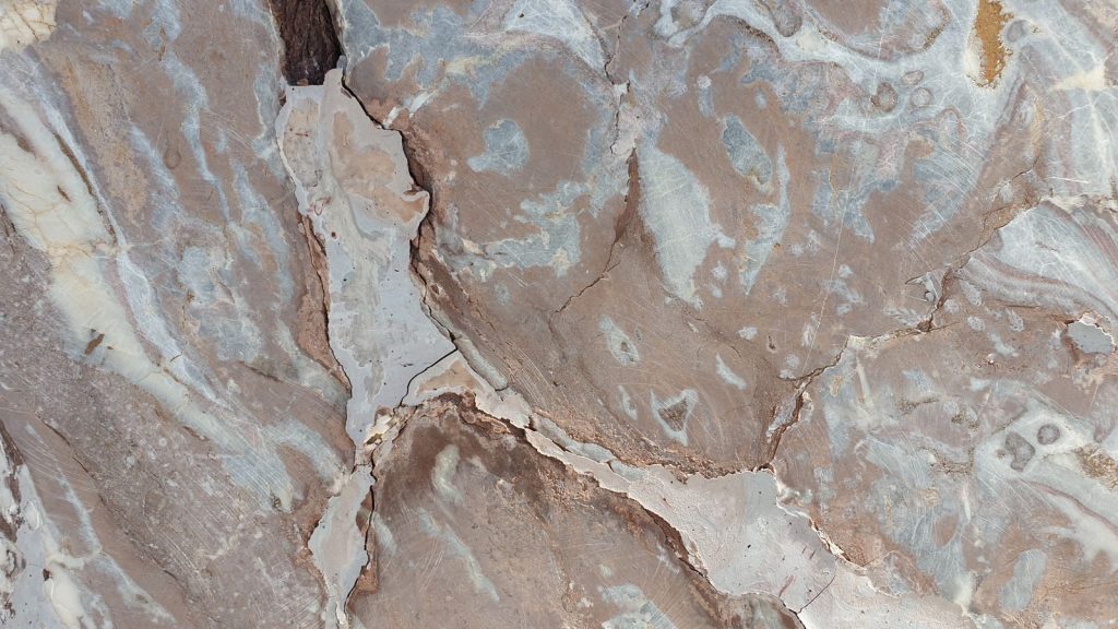 High-resolution image of a natural marble stone surface with intricate patterns and textures.