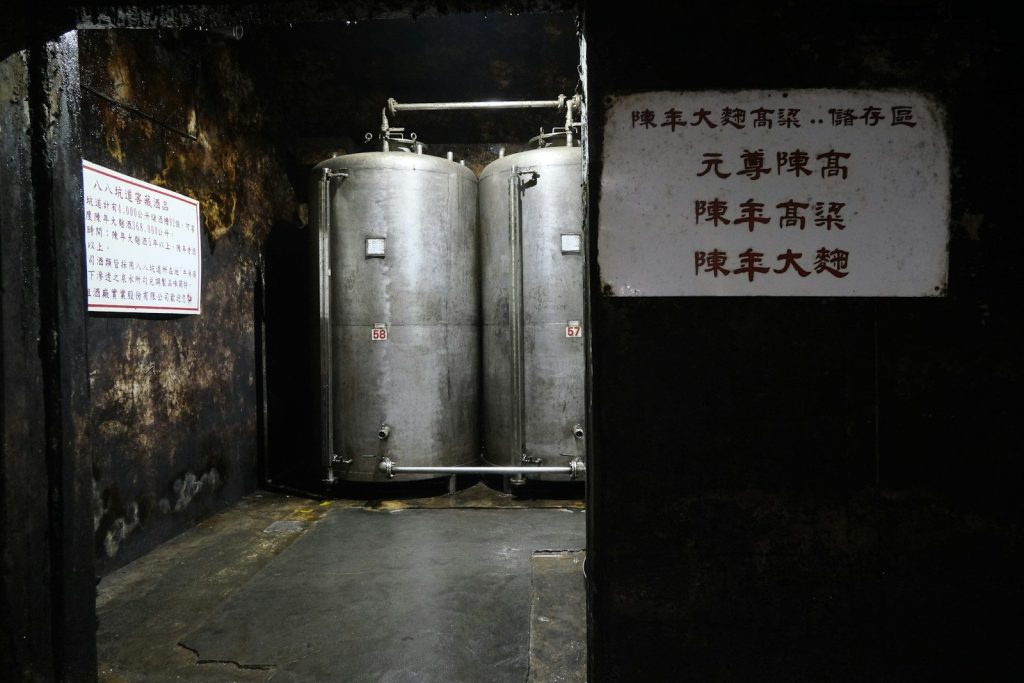 Two large stainless steel tanks in a dark room.