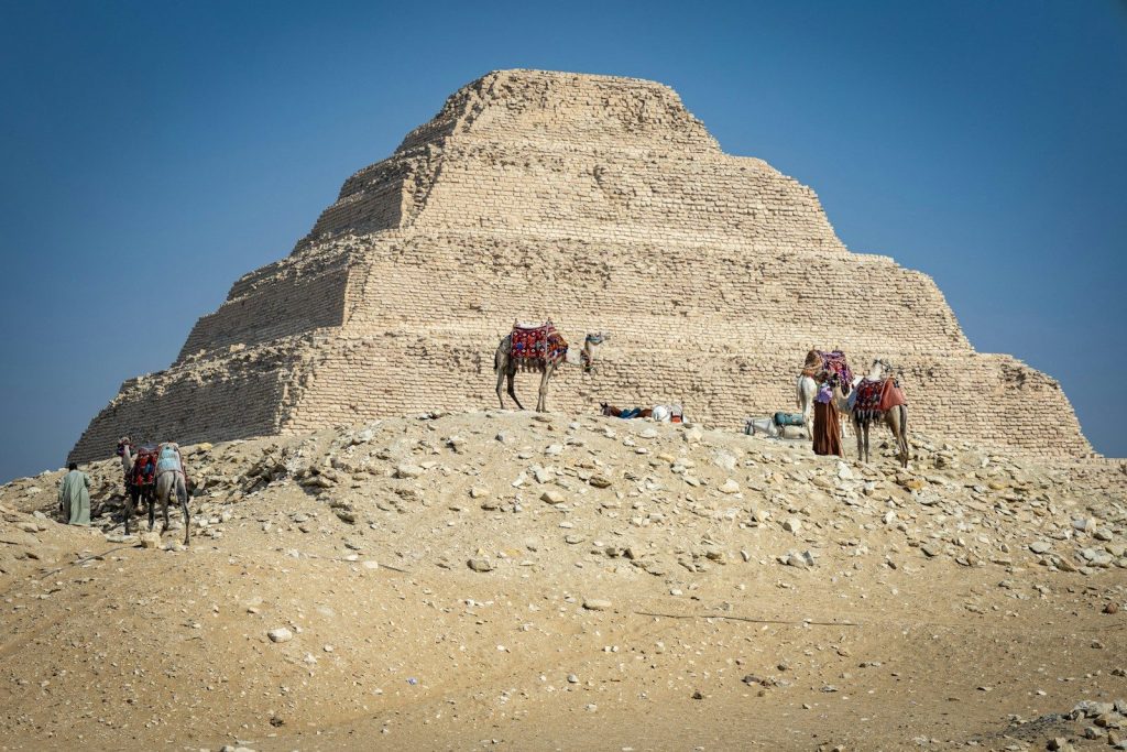 A group of horses standing in front of a pyramid