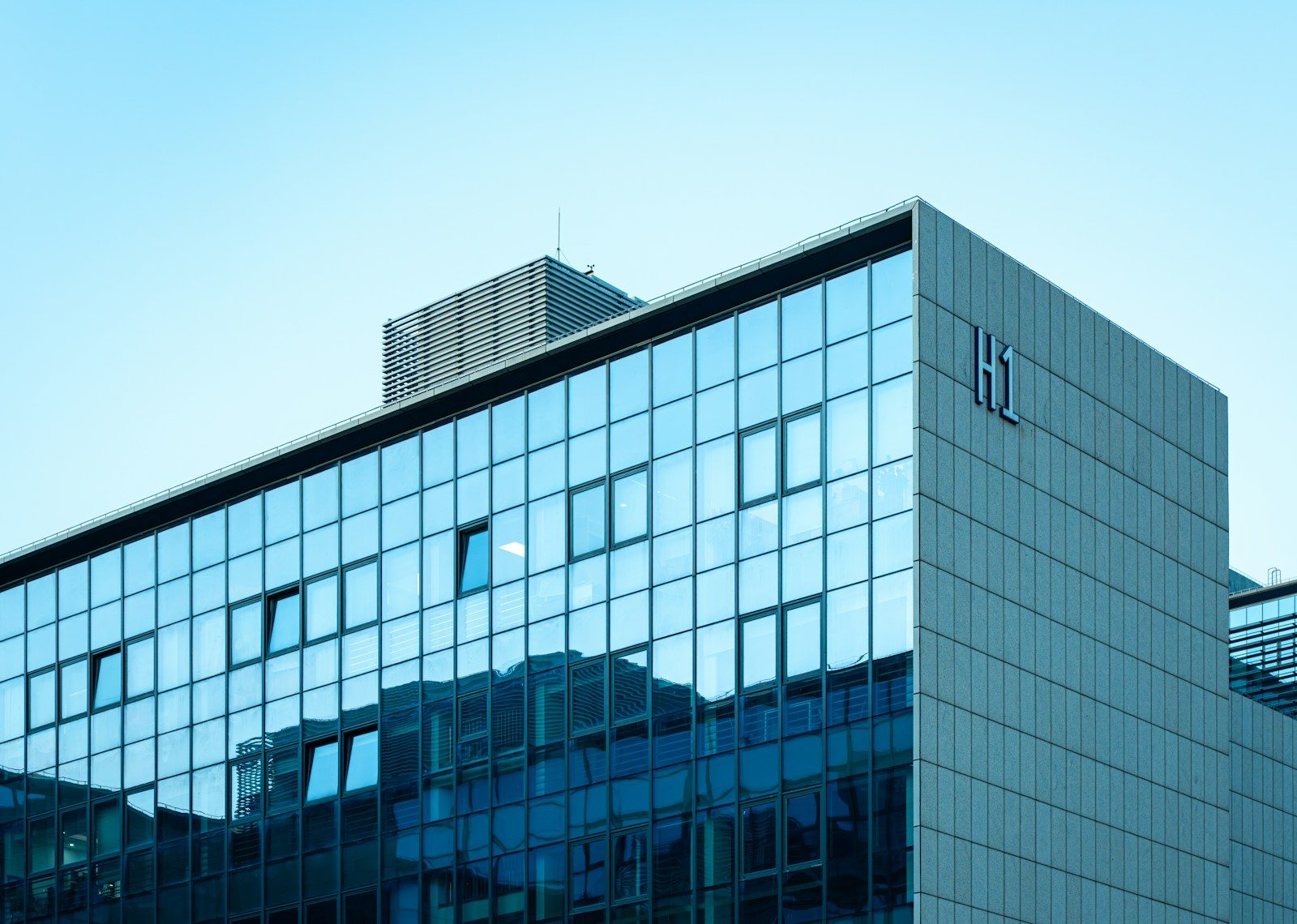 Modern glass building reflecting the clear sky