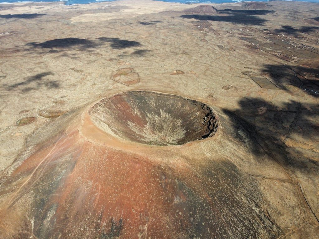 an aerial view of a desert landscape with a circular hole in the ground