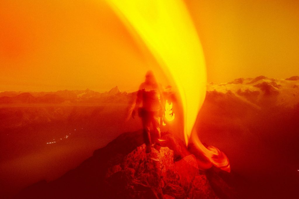 A fiery figure stands in a blaze of light.