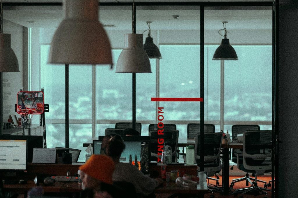 a group of people sitting at a desk with a large window