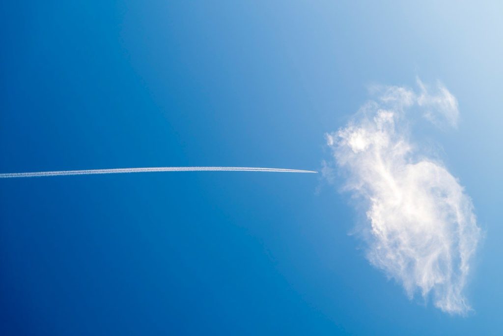 Airplane contrail interacts with a cloud.