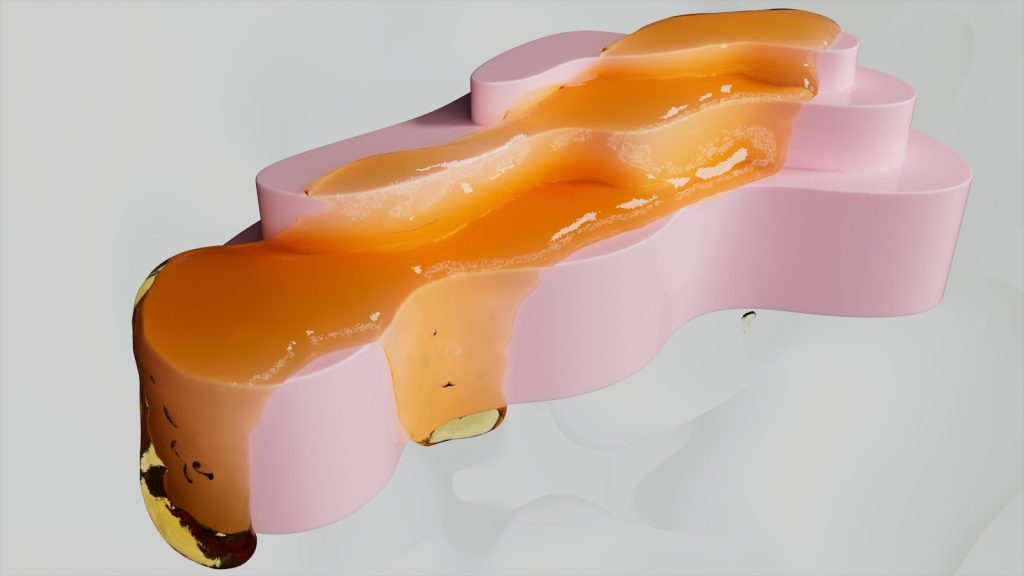 Orange glaze drips down a pink sculpture.