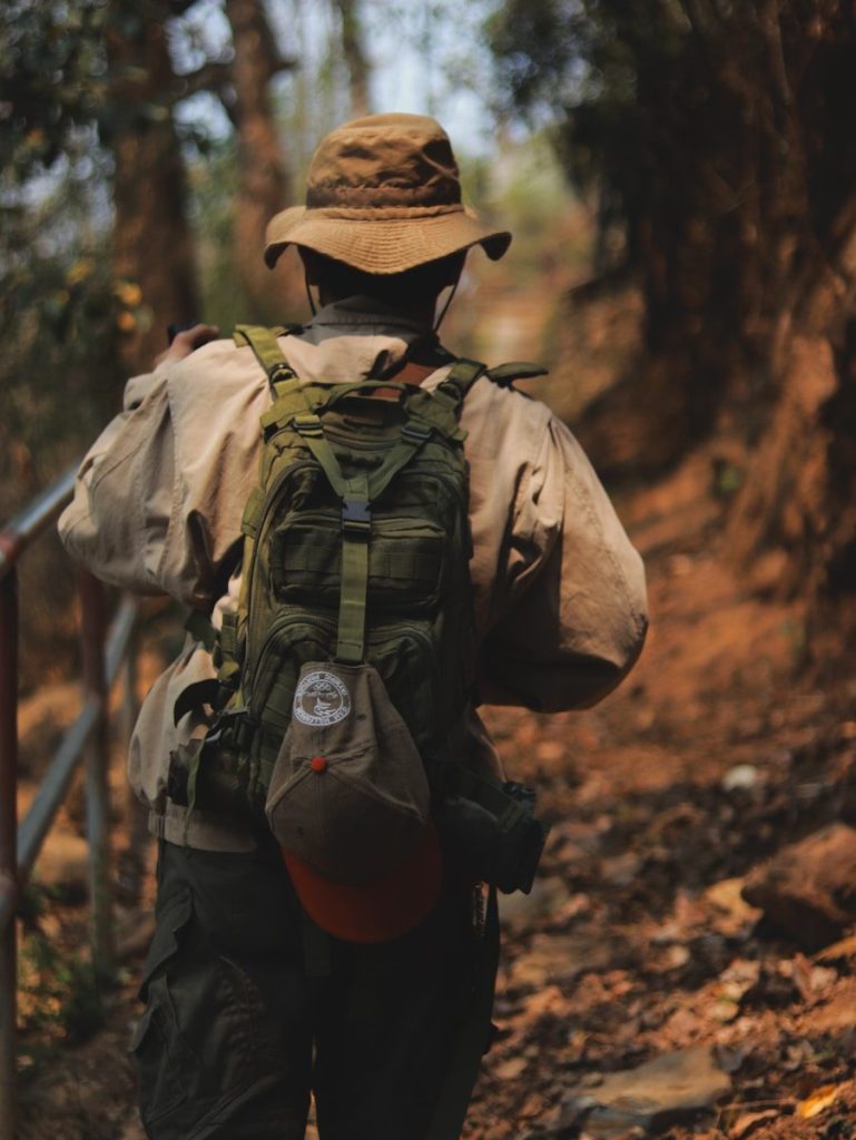 A man with a backpack walking up a trail