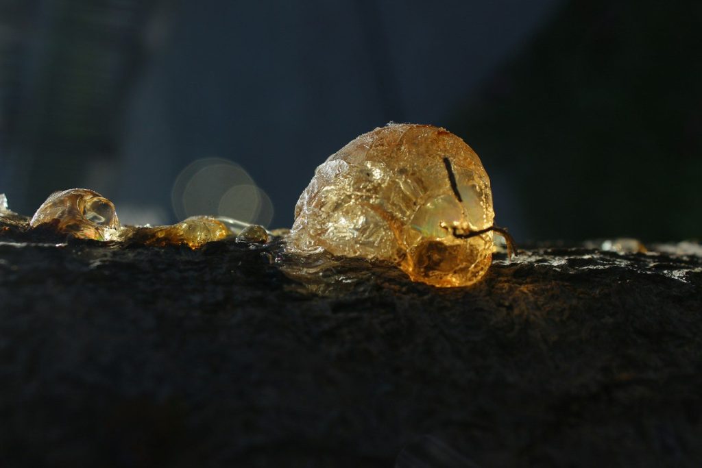 a piece of yellow glass sitting on top of a rock