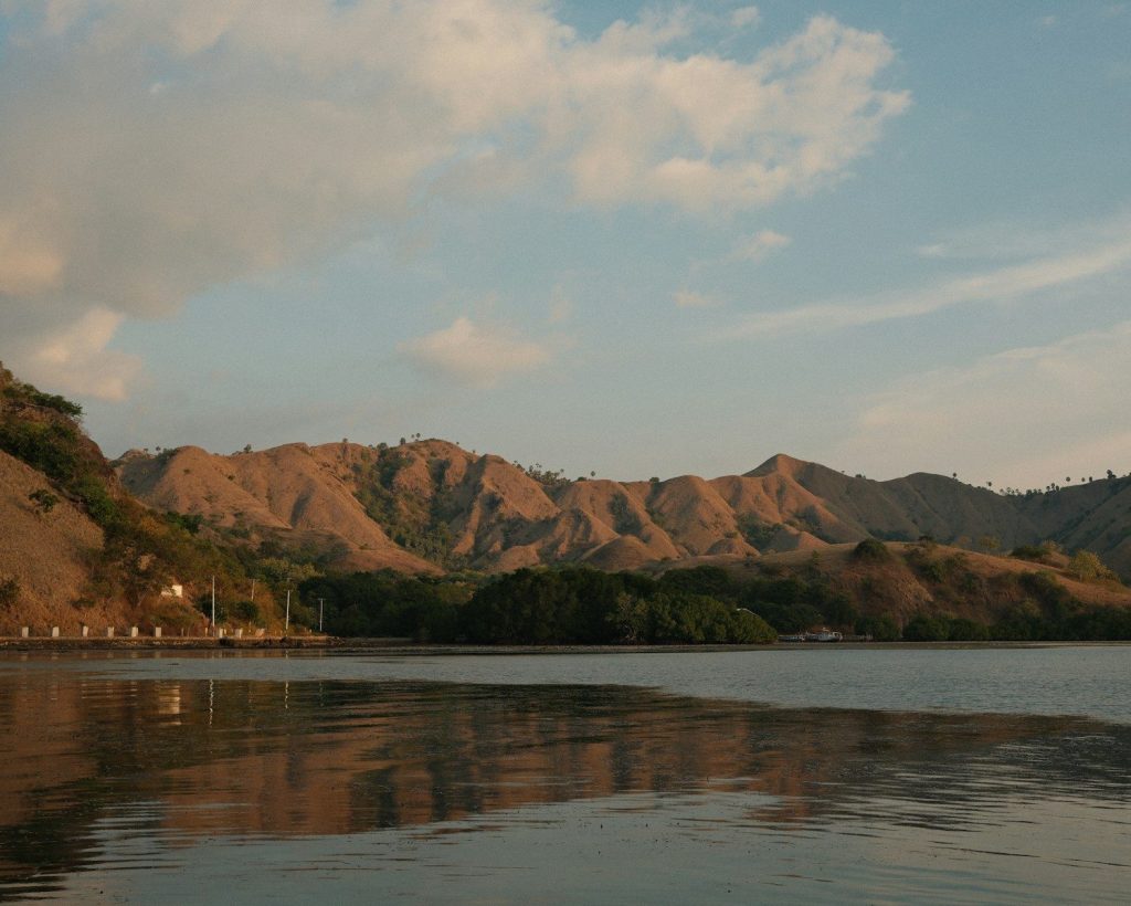 A body of water with mountains in the background