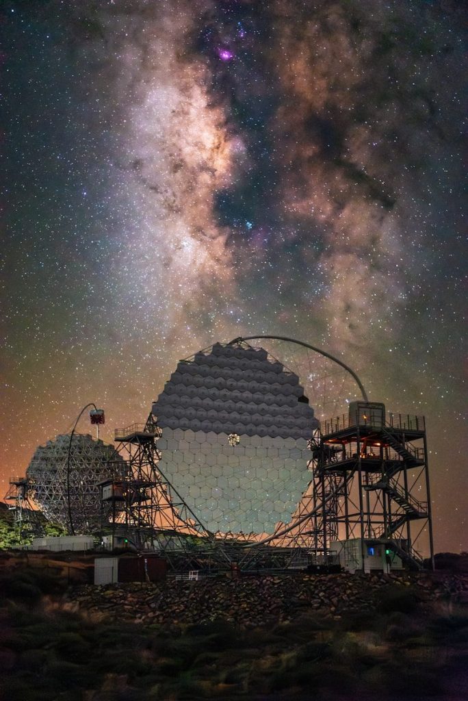 Telescopes beneath a starry night sky
