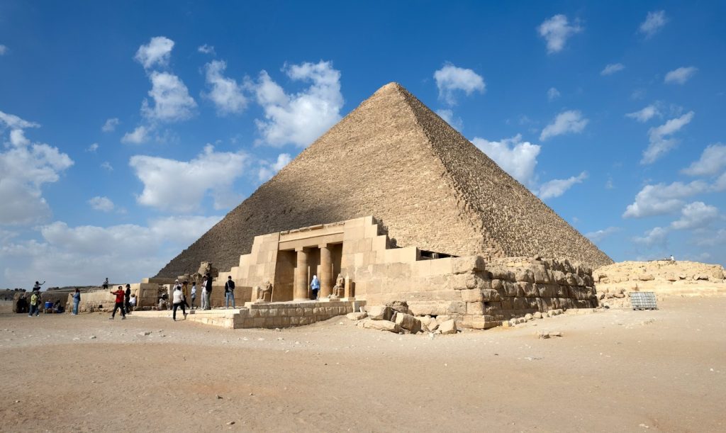 The great pyramid of giza under a blue sky.