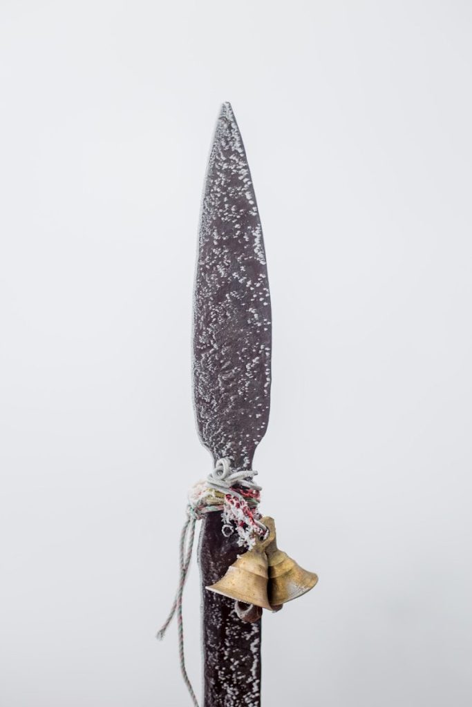 Close-up of a spearhead with bells attached bells