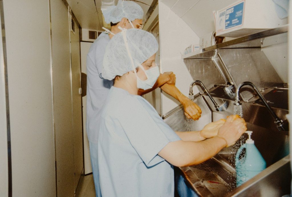 Two medical professionals scrubbing hands before surgery.