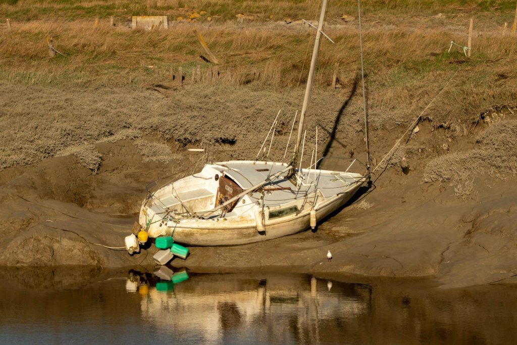 a boat sitting on top of a sandy beach